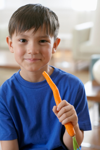Picture of a young boy smiling and eating a carrot - KalliKids articles